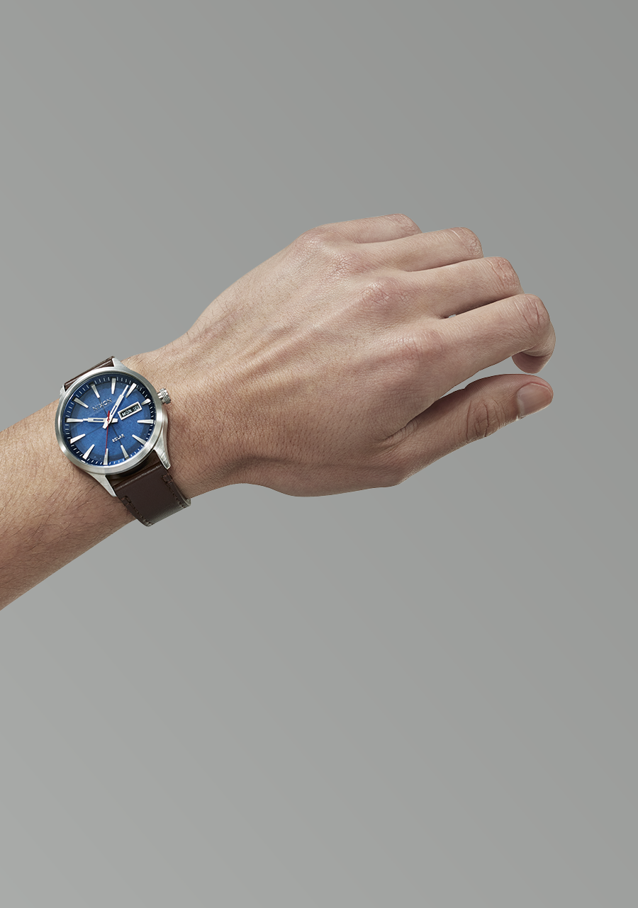 Wristwatch with a blue dial and silver case worn on a person’s wrist.