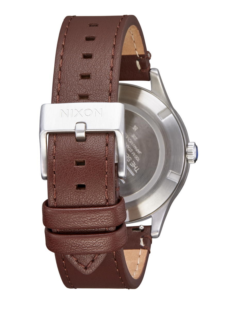 Brown leather watch strap with a silver buckle attached to a watch case.