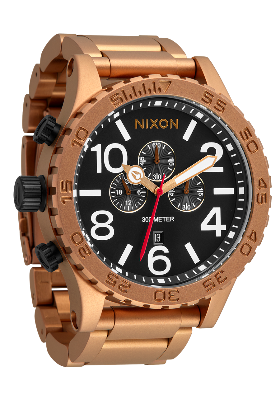 Rose gold-toned Nixon wristwatch with a black dial and chronograph subdials.