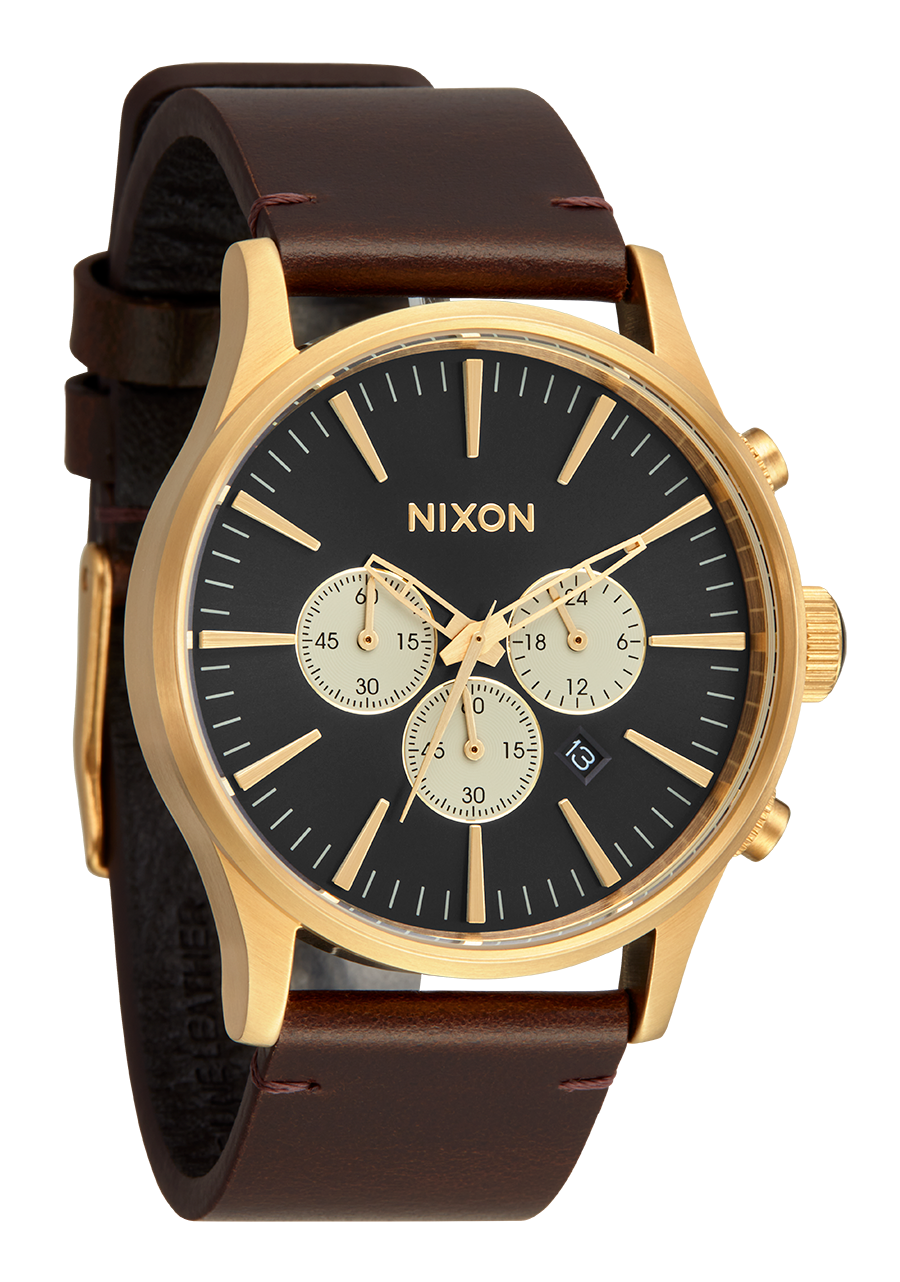Gold-toned Nixon wristwatch with a black dial and brown leather strap.