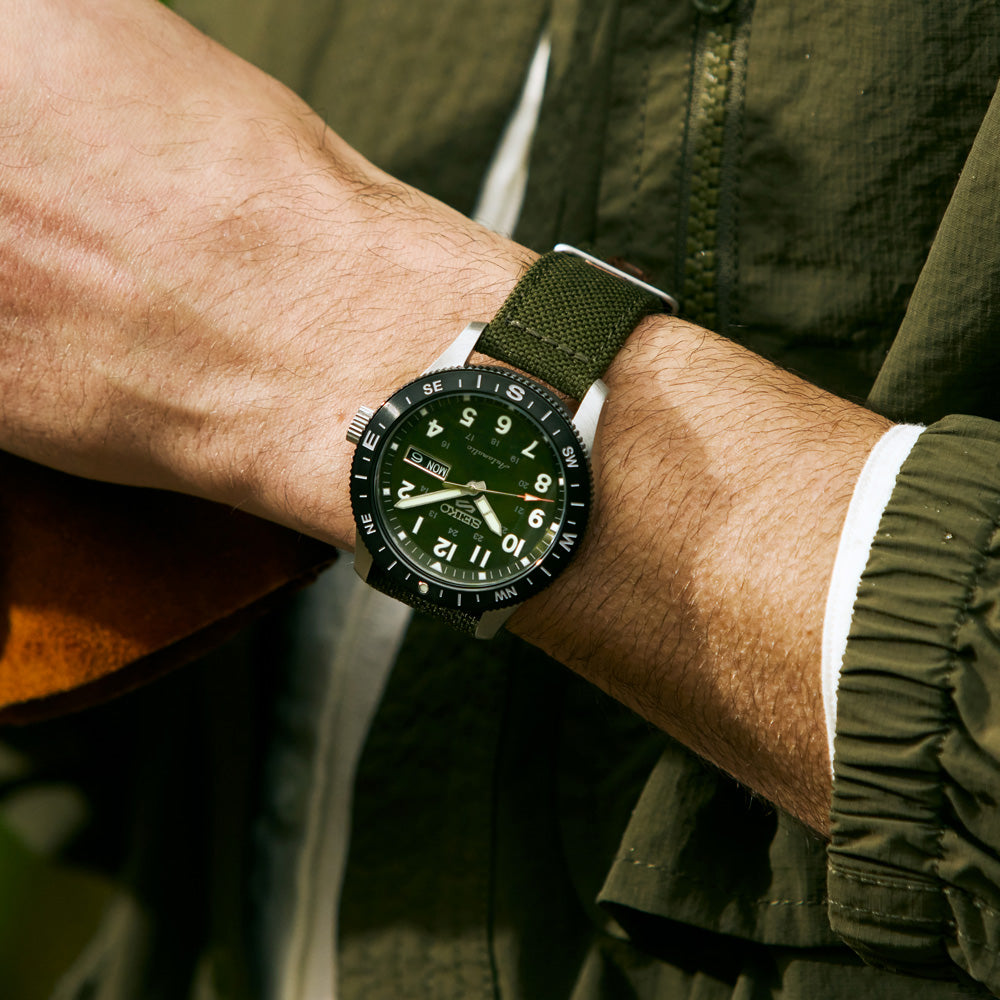 Angled view of the Seiko 5 Sports HDB008K green dial field watch on a nylon strap.