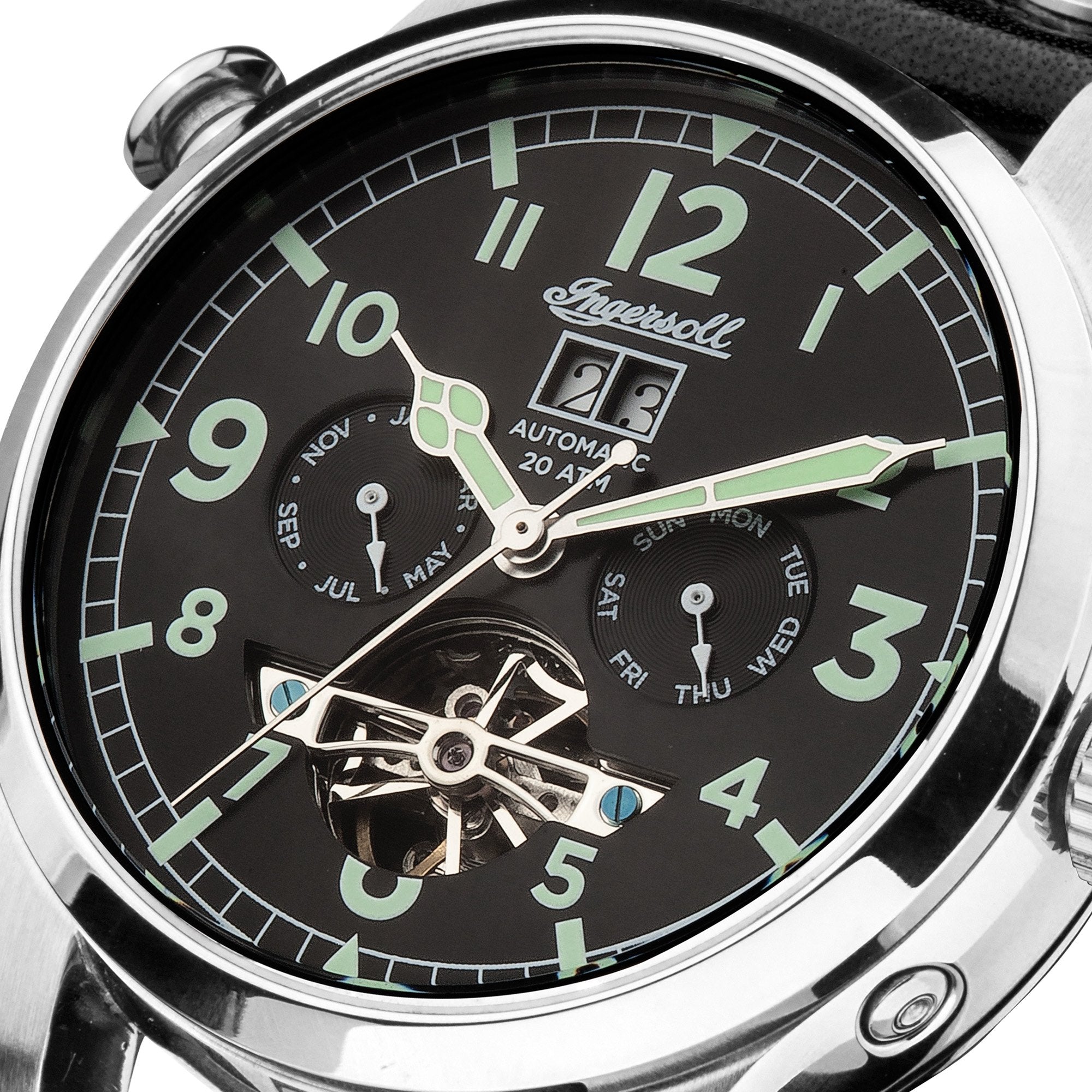 Elegant wristwatch with a black dial featuring luminous green numerals and hands, displaying date and day complications, and a visible skeleton mechanism at the bottom.