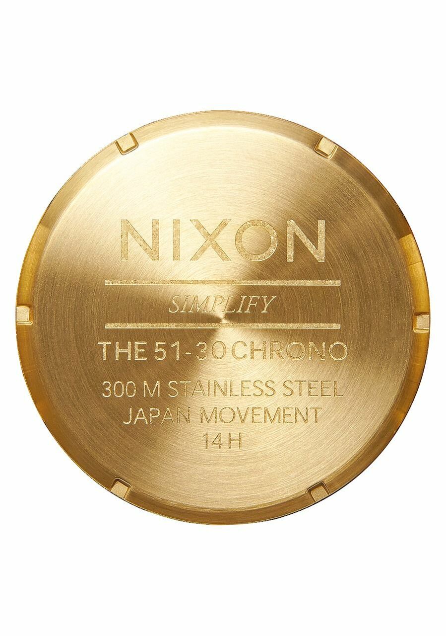 Gold-colored watch caseback with engraved text and specifications.