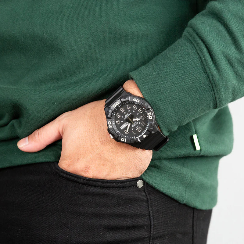 Wristwatch with a black face and bezel worn on a person’s wrist.