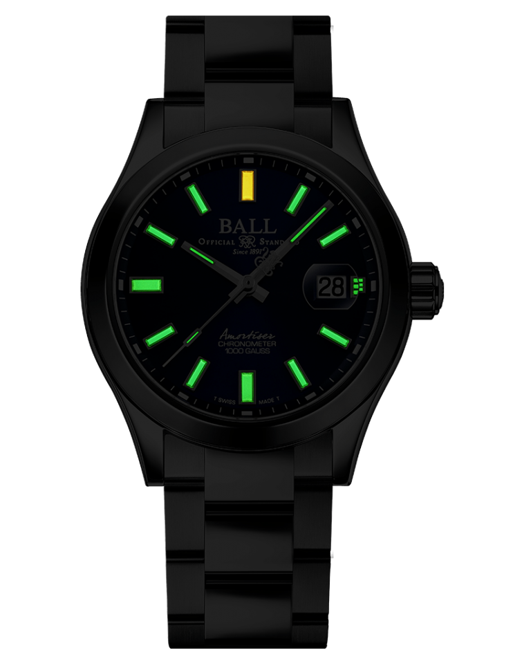 Black wristwatch with luminous green hour markers and a yellow marker at 12 o’clock.