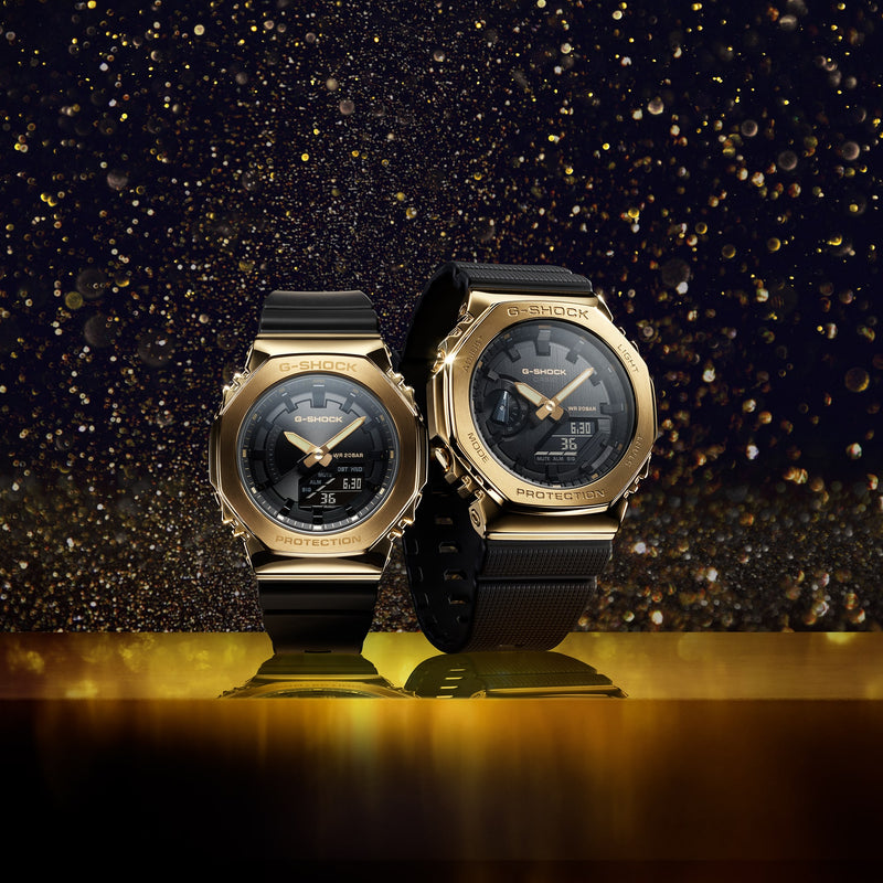 Two gold-toned luxury wristwatches with black bands.