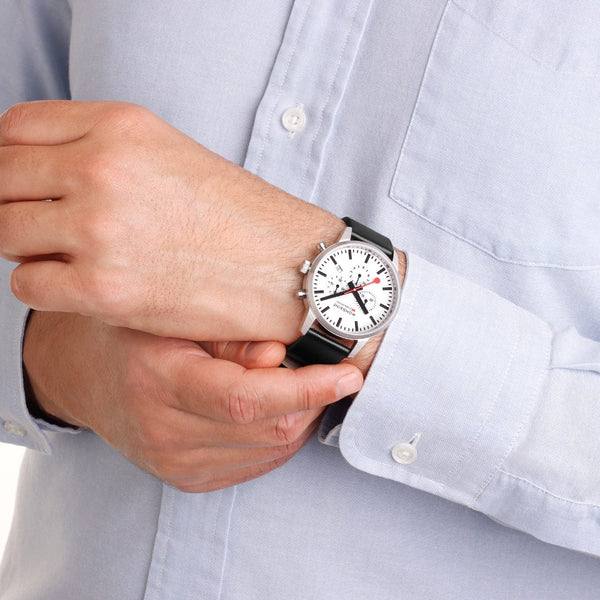 Wristwatch with a white face and black leather strap.