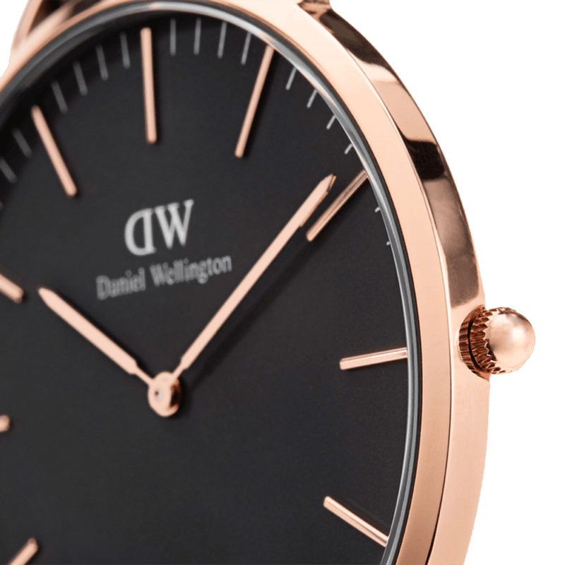 Elegant wristwatch with a black face and rose gold-toned case and markings.