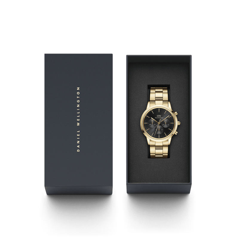 Gold-toned wristwatch with a black face in an open presentation box.