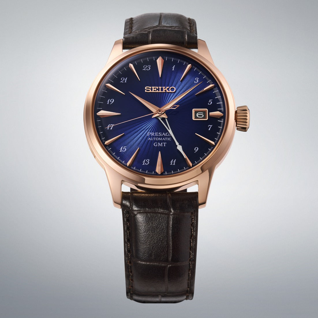 Seiko Presage Cocktail Time GMT HCB005J with blue dial, rose gold-tone case and brown leather strap, front view on a grey studio background — Watch Direct Australia
