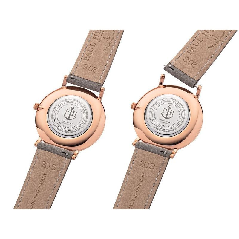 Two rose gold wristwatches with tan leather straps, showing their casebacks.