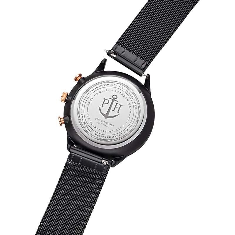 Back of a wristwatch with a black mesh strap and engraved metal case back.