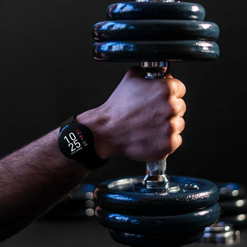 Dumbbell being gripped by a hand wearing a smartwatch.