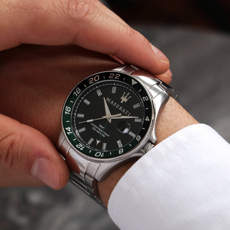 Stainless steel wristwatch with a black dial and green bezel.