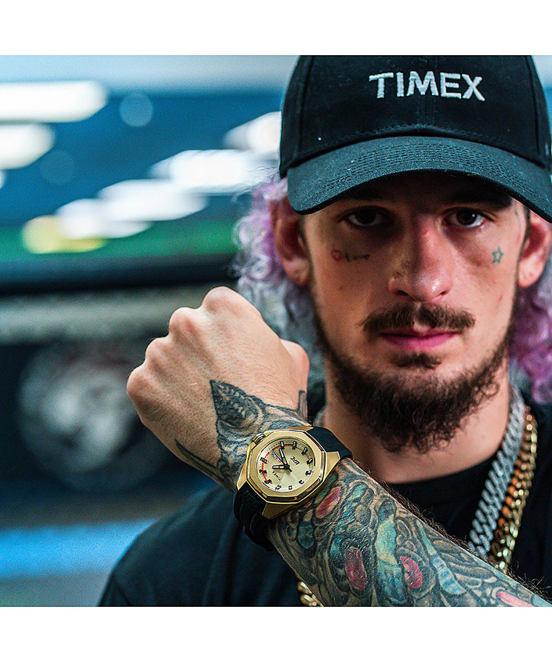 Gold Timex watch on a tattooed arm.