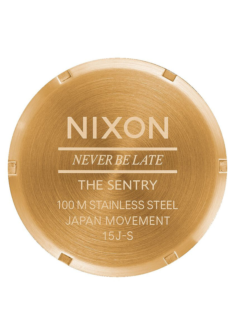 Circular gold-colored watch caseback with engraved text.