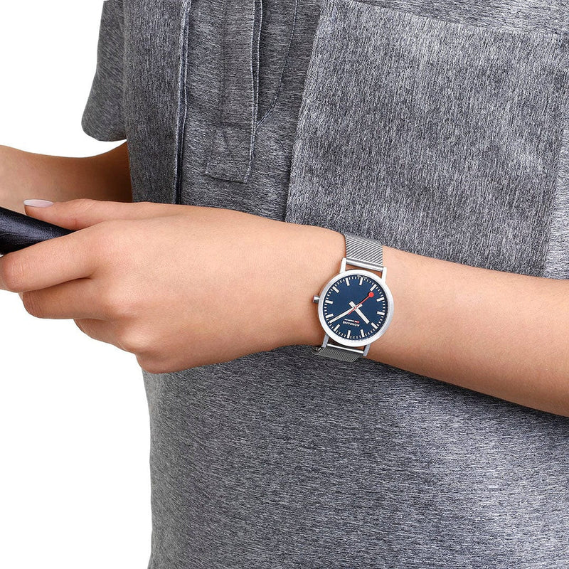 Wristwatch with a blue face and silver metal band.