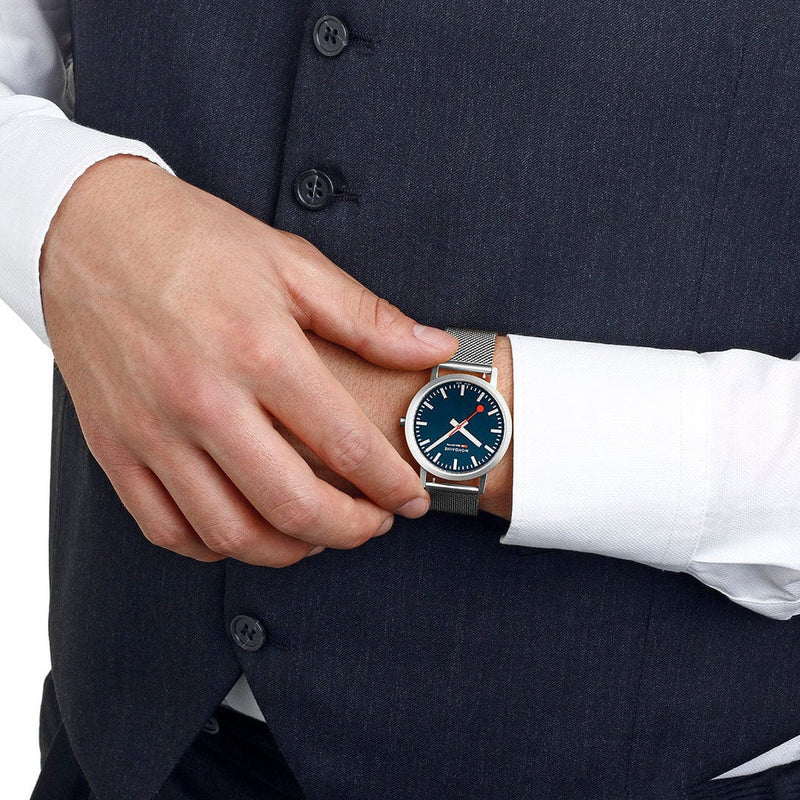 Wristwatch with a blue dial and silver mesh band.