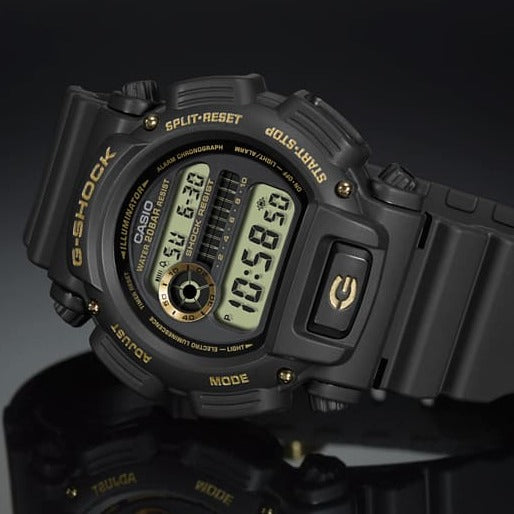 Digital sports watch with a black resin band and gold accents on the face.