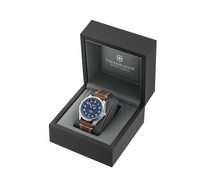 Wristwatch with a blue dial and brown leather strap in a black presentation box.