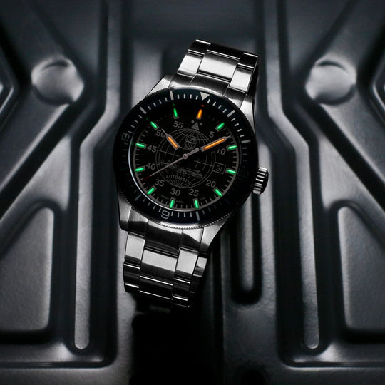 Sleek stainless steel wristwatch with a black dial and luminous green and orange markers.