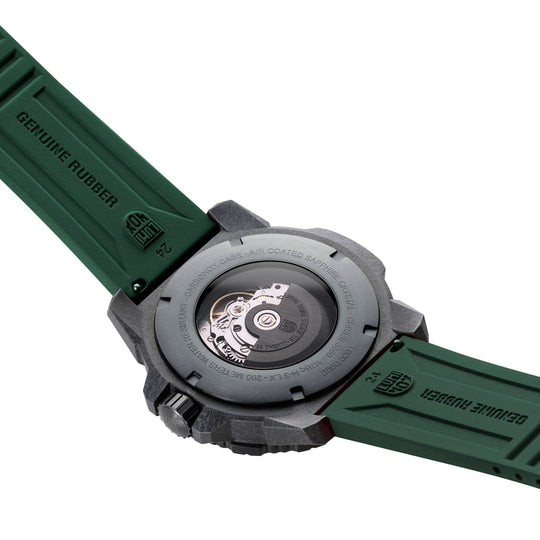 Wristwatch with a green rubber strap and visible mechanical movement through the case back.