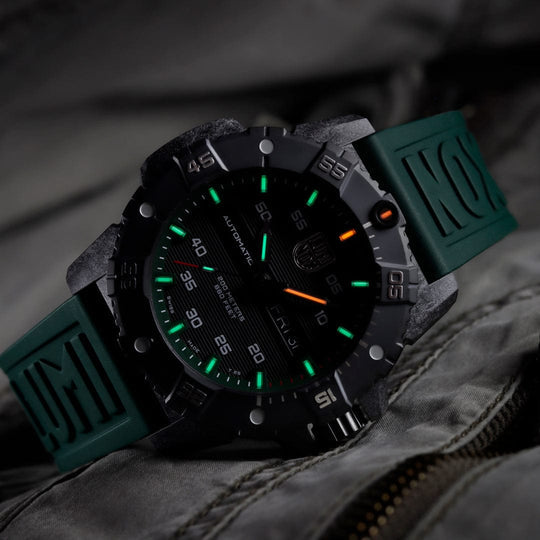Rugged sports watch with a black face, green luminous markers, and a green rubber strap.