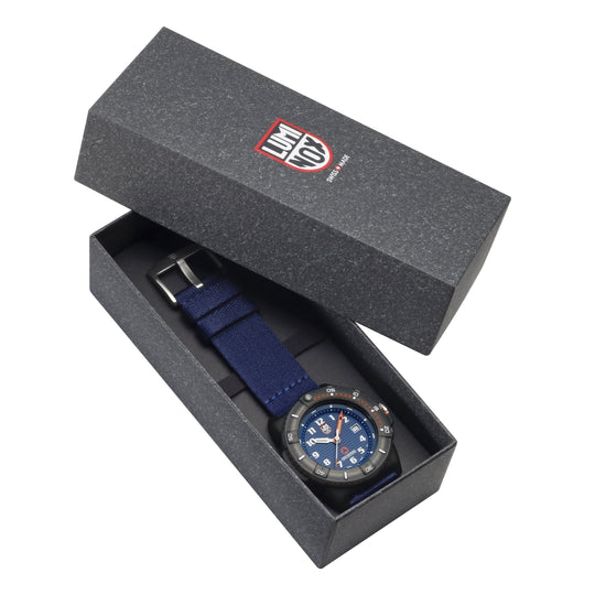 Wristwatch with a blue face and navy strap in an open gift box.