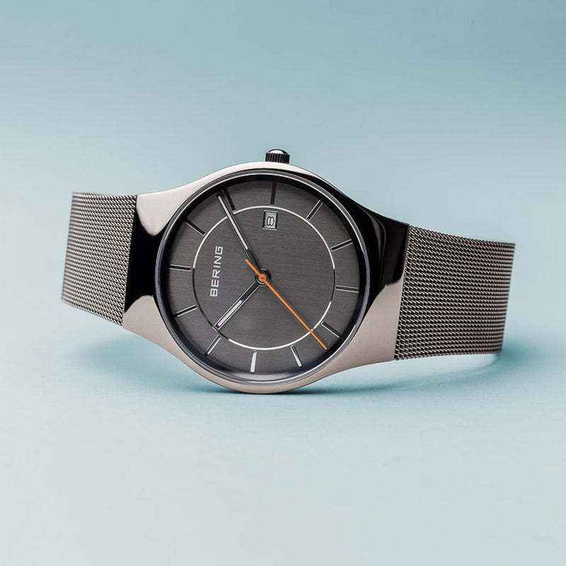 Sleek wristwatch with a gray dial and mesh metal band.